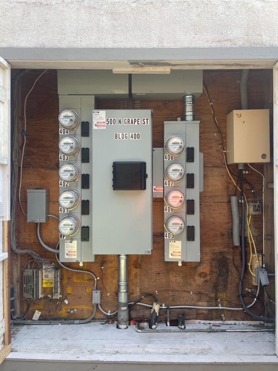 Multi-meter service panel labeled 500 N Grape St BLDG 400 — property management work